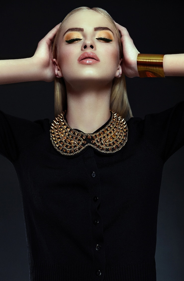 Foto grátis alta moda look.glamor closeup retrato do modelo sexy elegante loira jovem bonita com maquiagem amarela brilhante com pele limpa perfeita com jóias de ouro em pano preto