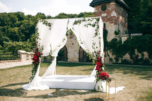 Altar de casamento feito de cortinas quadradas fica no quintal