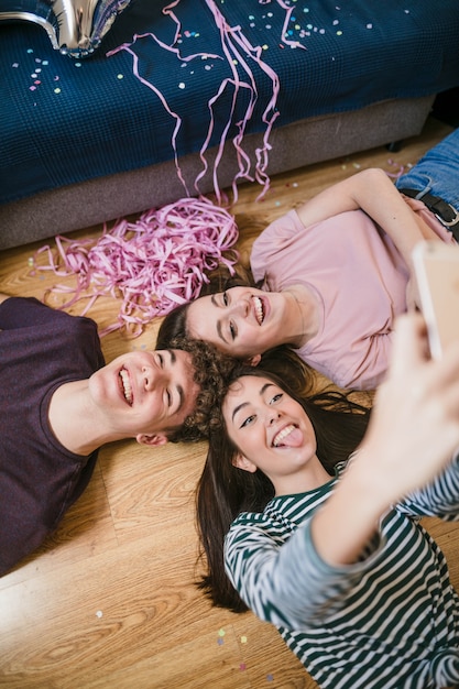 Foto grátis alto ângulo amigos tomando uma selfie no chão