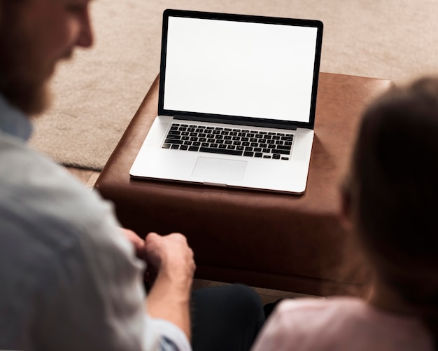 Alto ângulo da menina e do pai passando um tempo juntos ao lado do laptop