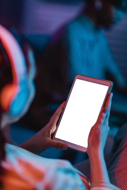 Foto grátis alto ângulo da mulher em casa usando fones de ouvido e tablet