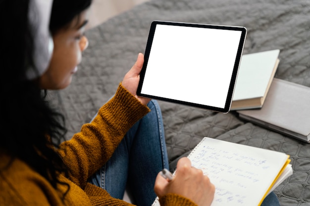 Foto grátis alto ângulo de adolescente usando tablet para escola online