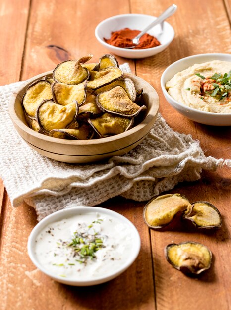 Alto ângulo de batatas assadas com molho e homus