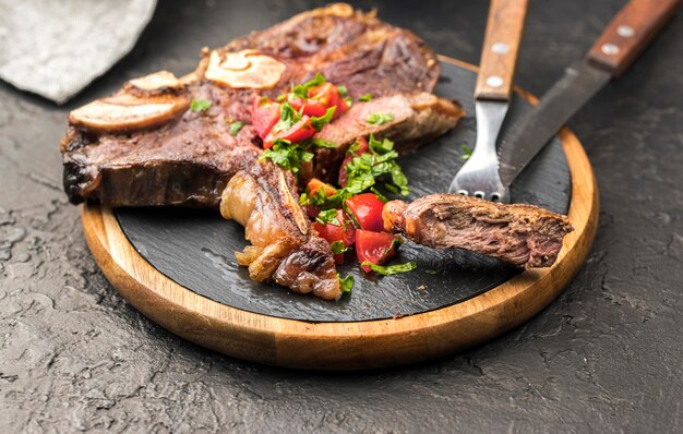 Alto ângulo de bife com talheres