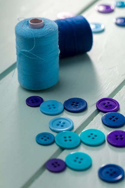 Foto grátis alto ângulo de bobinas de fio com botões azuis