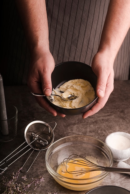 Alto ângulo de cozinheiro, mostrando a mistura na tigela