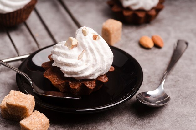 Alto ângulo de cupcake com cobertura e cubos de açúcar