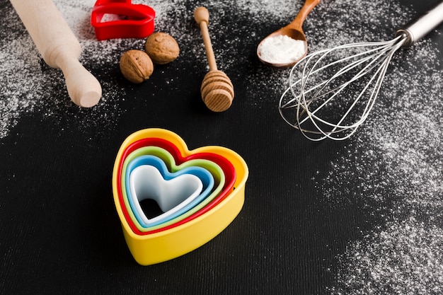 Alto ângulo de formas de coração colorido com utensílios de cozinha
