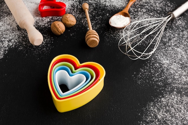 Foto grátis alto ângulo de formas de coração colorido com utensílios de cozinha