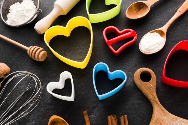 Alto ângulo de formas de coração colorido com utensílios de cozinha