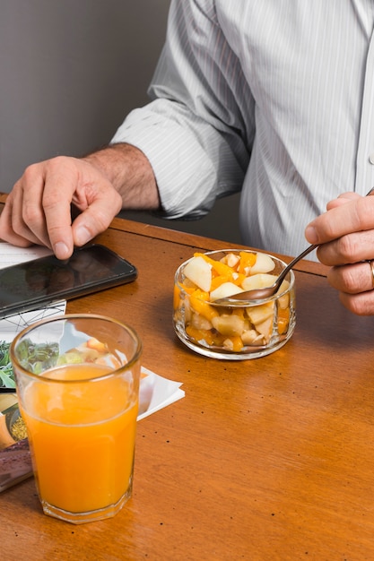 Foto grátis alto ângulo de homem com copo de suco e comida saudável