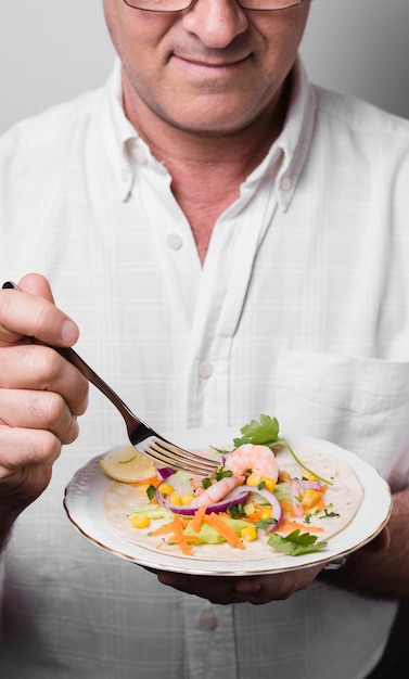 Alto ângulo de homem segurando o prato com comida saudável