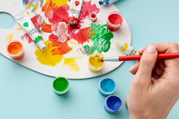 Foto grátis alto ângulo de mão e paleta colorida