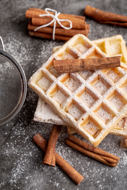 Foto grátis alto ângulo de paus de canela em waffles de açúcar em pó