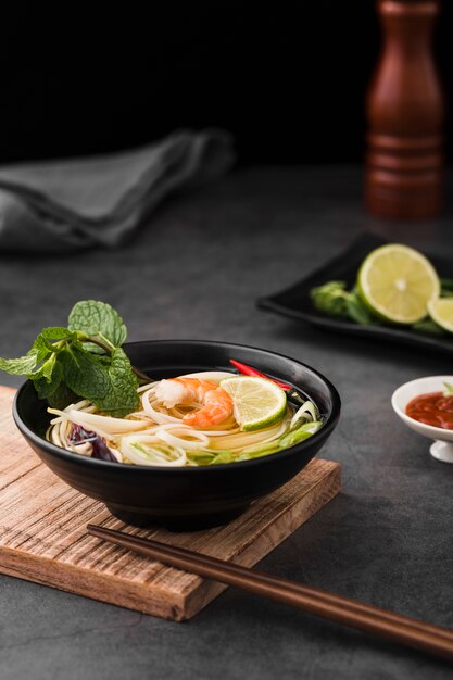 Alto ângulo de sopa com macarrão e pauzinhos