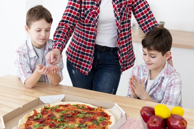 Alto ângulo de tipos higienizando as mãos antes de comer pizza