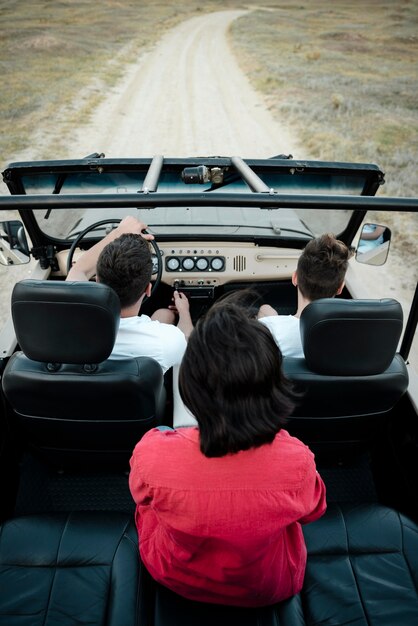 Alto ângulo de três amigos viajando juntos de carro