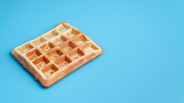 Alto ângulo de waffle em fundo azul, com espaço de cópia