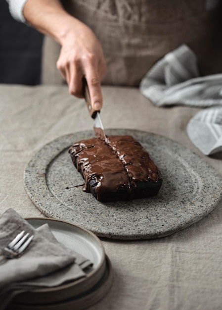 Alto ângulo do chef confeiteiro cortando bolo de chocolate