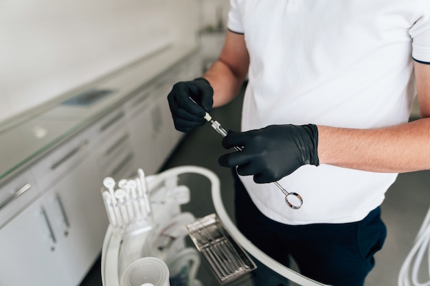 Foto grátis alto ângulo do dentista segurando o equipamento