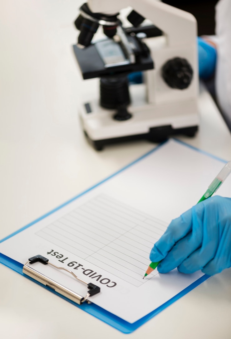 Foto grátis alto ângulo do microscópio no laboratório e no bloco de notas
