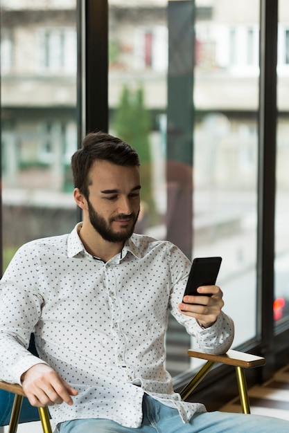 Alto ângulo masculino olhando para celular