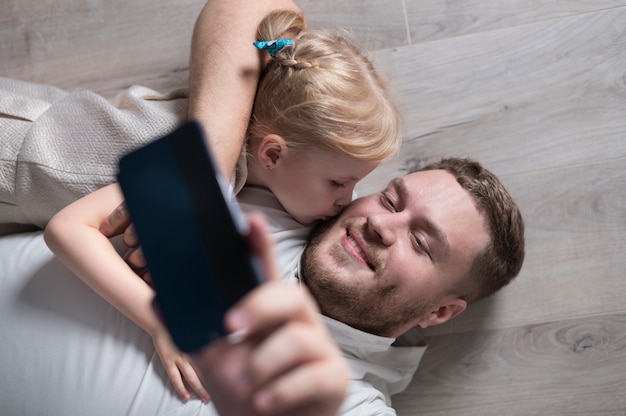 Alto ângulo pai e filha tomando uma selfie