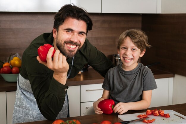 Alto ângulo pai e filho segurando legumes