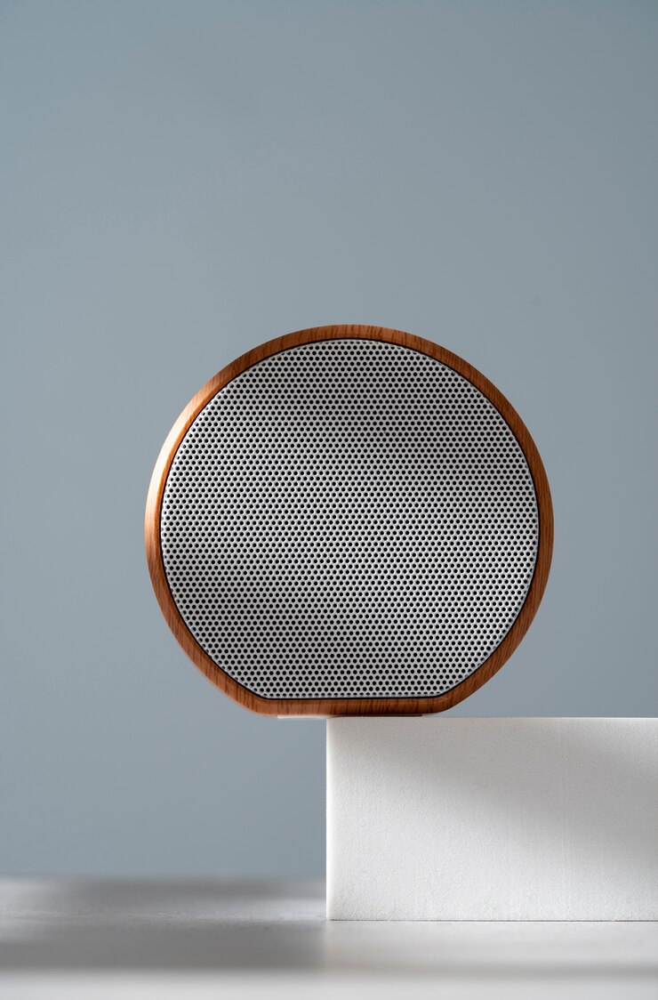 Foto grátis alto-falante redondo sem fio moderno com design elegante exibido em um pódio geométrico