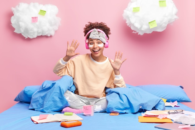 Foto grátis aluna afro-americana alegre e positiva levantando as mãos e se sentindo despreocupada