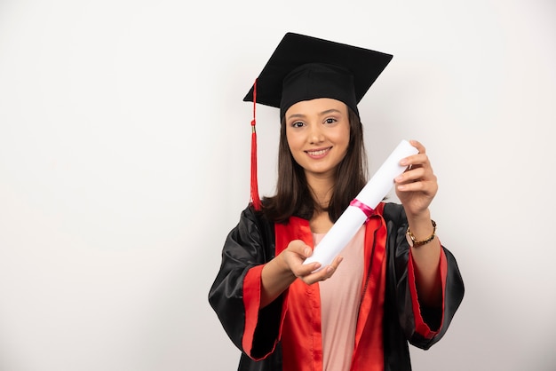 Aluna de pós-graduação mostrando seu diploma em fundo branco.