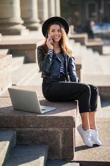 Aluna jovem empresária trabalha com seu laptop de marca no centro da cidade