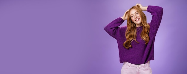 Foto grátis aluna ruiva alegre e despreocupada e estilosa com um suéter quente roxo aproveitando as férias