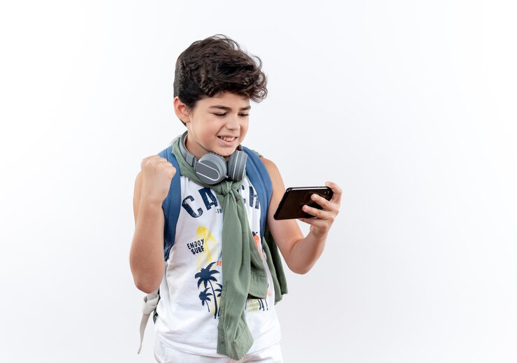 Foto grátis aluno alegre usando mochila e fones de ouvido brincando no telefone e mostrando um gesto de sim