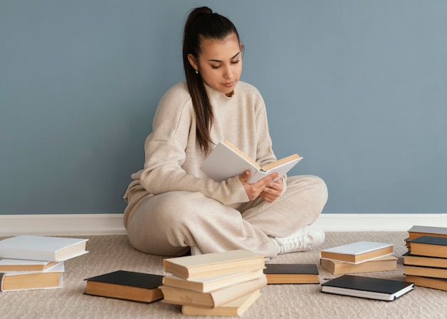 Foto grátis aluno de tiro completo com livros no chão