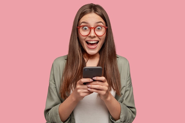 Foto grátis aluno muito feliz posando contra a parede rosa