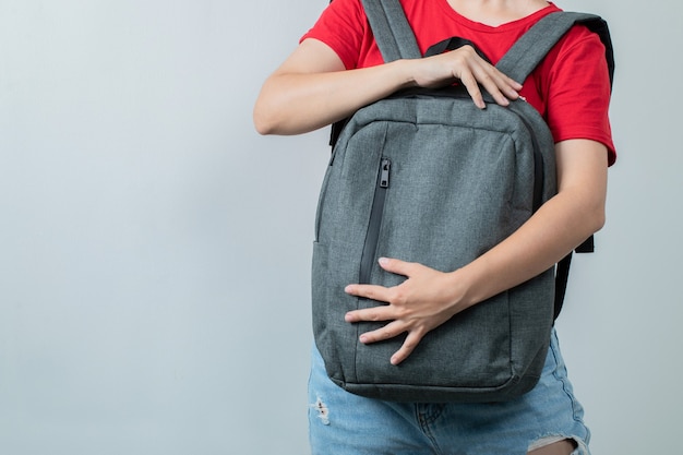 Foto grátis aluno segurando a mochila cinza na frente