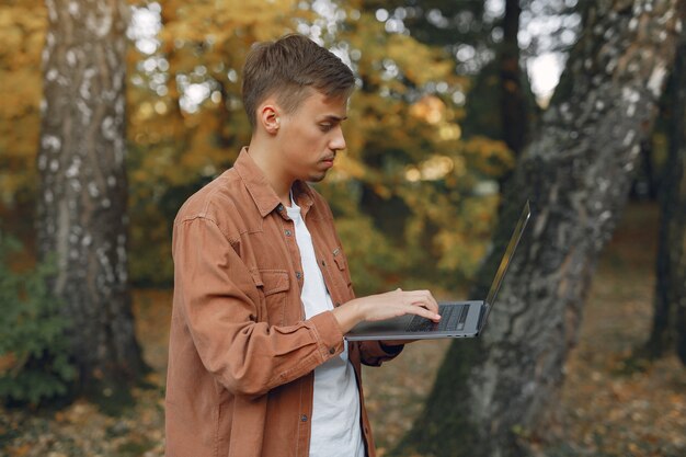 Aluno trabalhando em um parque e usar o laptop