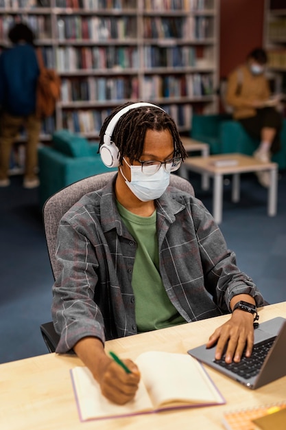 Aluno usando uma máscara facial na biblioteca