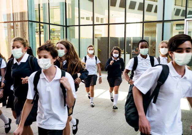 Alunos do ensino médio usando máscaras no caminho para casa