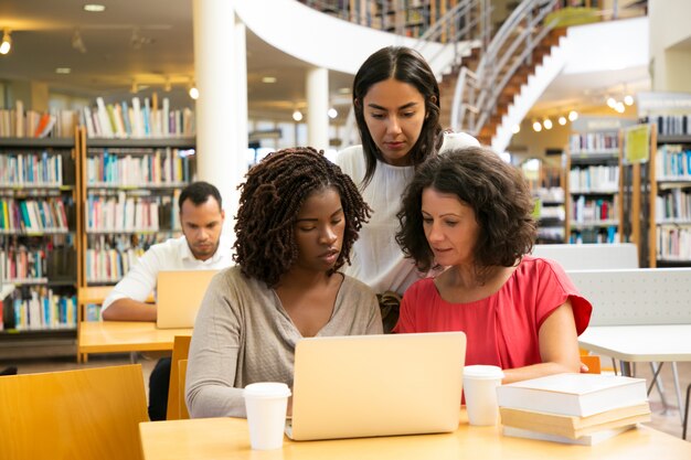 Alunos focados trabalhando em novo projeto na biblioteca