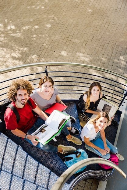 Foto grátis alunos sentados com livros nas escadas