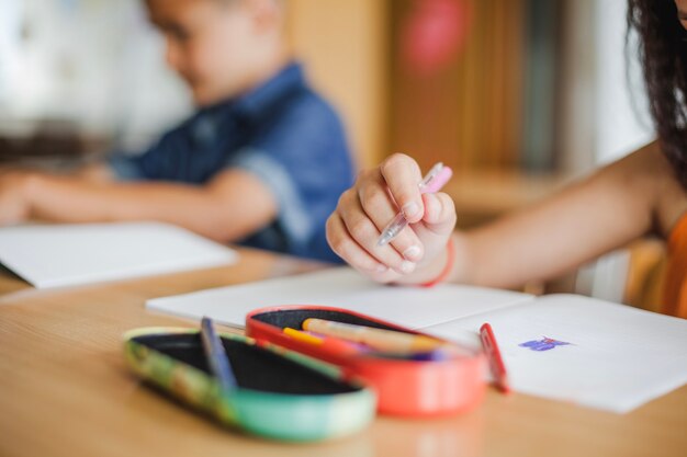 Alunos sentados na mesa com cadernos