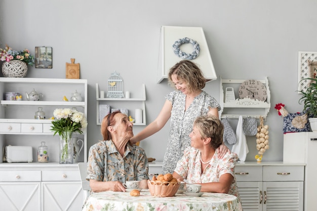 Amando três mulheres de geração tomando café da manhã em casa