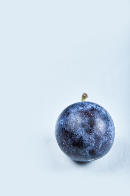 Ameixa fresca madura sobre um fundo azul. Foto de alta qualidade