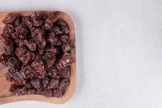 Foto grátis ameixas marrons secas em uma bandeja de madeira.