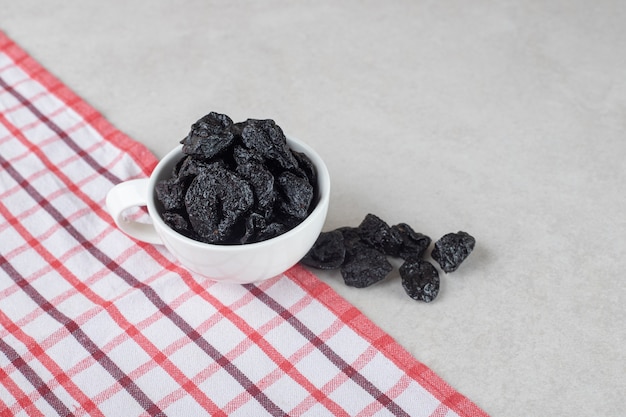 Foto grátis ameixas pretas secas em um prato de cerâmica.