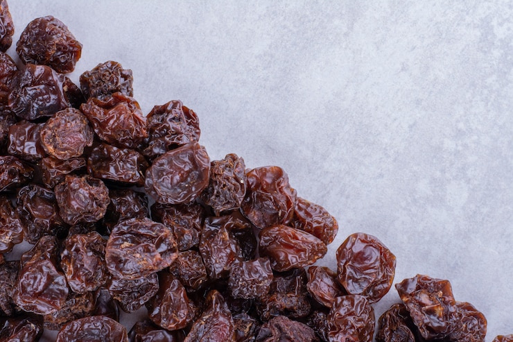 Foto grátis ameixas secas de cereja azeda isoladas na superfície do concreto