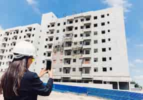 Foto grátis americano africano, senhora, em, capacete segurança, levando, foto, de, predios, construção