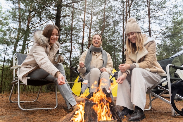 Amigas assando marshmallows usando uma fogueira